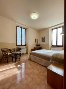 Schlafzimmer mit einem Bett, einem Tisch und Stühlen in der Unterkunft Locanda Settecamini in Campello sul Clitunno