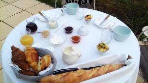 a white table with breakfast foods and drinks on it at La part des Anges in Gouze