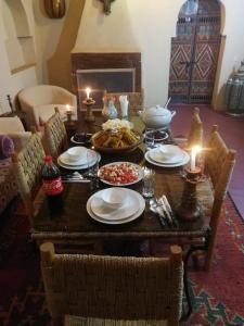 una mesa con platos de comida y velas. en Chez Kossai Atlas Farm, en Chtawna