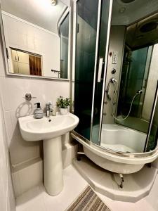 a bathroom with a sink and a glass shower at Orange in Almaty