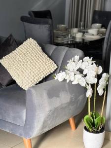 - un canapé gris avec des oreillers et des fleurs dans le salon dans l'établissement Acogedor departamento en el Golf, à Víctor Larco Herrera