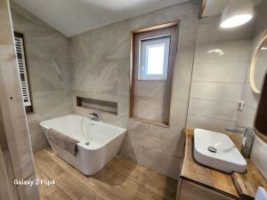a bathroom with a white tub and a sink at Petite maison cosy in Hyères