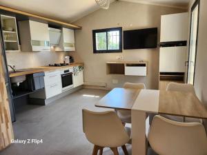 - une cuisine avec une table et des chaises dans la chambre dans l'établissement Petite maison cosy, à Hyères