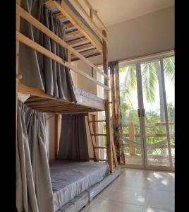 a bedroom with bunk beds and a large window at La Palmera Hostel in Puerto Escondido