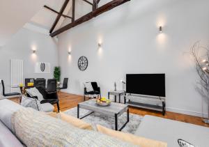 a living room with a couch and a tv at Oddfellows Hall in Holt