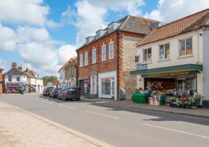 a street in a town with buildings and a store at Oddfellows Hall in Holt