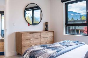 a bedroom with a dresser and a mirror at Bluebird Daze by Revelstoke Vacations in Revelstoke