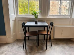 格拉斯哥的住宿－Cozy Studio Apartment of Glasgows West End，一张桌子,上面有两把椅子和盆栽植物