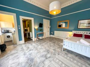 sypialnia z białym łóżkiem i niebieską ścianą w obiekcie Cozy Studio Apartment of Glasgows West End w Glasgow