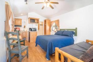 a bedroom with a bed and a kitchen with a table at The Lupine Cabin #10 at Blue Spruce RV Park & Cabins in Tuckerville