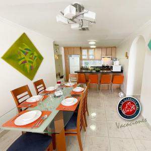 a dining room and kitchen with a table and chairs at Departamento con 3 habitaciones, con capacidad para 8 personas, frente al mar in Tonsupa
