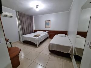 a hotel room with two beds and a window at Marion Pantanal Hotel in Várzea Grande