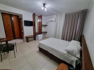 a hotel room with a bed and a television at Marion Pantanal Hotel in Várzea Grande