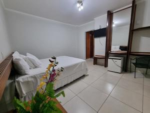 a hotel room with a bed and a table at Marion Pantanal Hotel in Várzea Grande