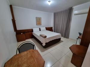 a hotel room with a bed and a window at Marion Pantanal Hotel in Várzea Grande