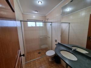 a bathroom with a toilet and a sink and a shower at Marion Pantanal Hotel in Várzea Grande