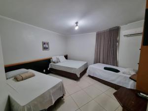 a hotel room with two beds and a window at Marion Pantanal Hotel in Várzea Grande
