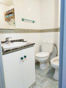 een witte badkamer met een toilet en een wastafel bij El refugio de lastres in Lastres