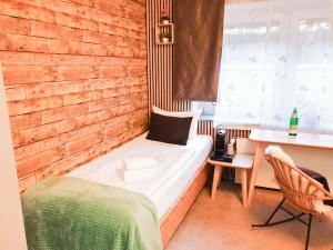 Habitación pequeña con cama, escritorio y escritorio. en Hotel Fürst Garden, en Dortmund