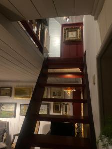eine Treppe, die zu einem Raum mit Gemälden führt in der Unterkunft La Maisonnette des Hêtres Rouges in Spa