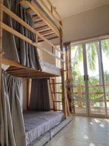 a bunk bed in a room with a large window at La Palmera Hostel in Puerto Escondido
