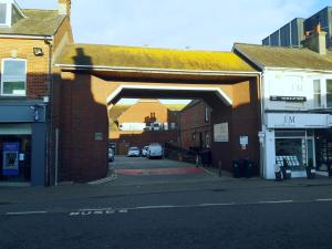 um edifício de tijolos com um arco sobre uma rua em Freame House Loft Cosy Easter Getaway Christchurch em Christchurch