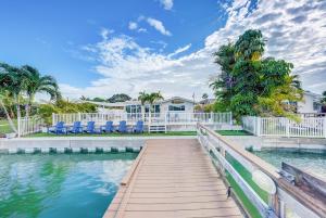 a boardwalk leading to a house with chairs and water at Fall Promo! Heated Pool, 6p Golf Cart, Kayak in Clearwater Beach