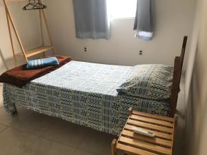 ein Schlafzimmer mit einem Bett und einem Holzstuhl in der Unterkunft Pousada São Pedro in Aracruz