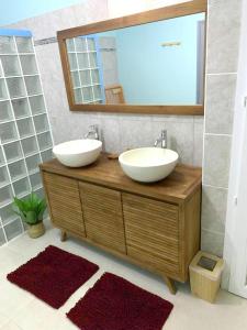 Baño con 2 lavabos y espejo en Maison de 2 chambres avec piscine privee spa et jardin clos a Riviere Salee, en Rivière-Salée