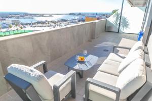 a balcony with white chairs and a table with a view at Casa Luz de Rajamanta - Terraza vistas a 1º línea y Parking in Barbate