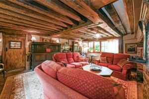 een woonkamer met rode banken en een tafel bij Hell Fyre 1594 by Inspire Stays in Itchingfield