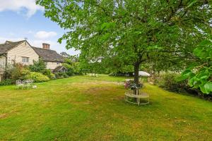een tuin met twee picknicktafels en een boom bij Hell Fyre 1594 by Inspire Stays in Itchingfield