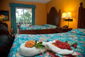 Un dormitorio con dos camas con flores. en Hotel Palma Real, en Sambo Creek