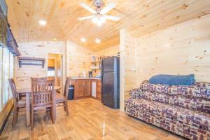 a living room with a couch and a table and a refrigerator at The Shooting Star Cabin #11 at Blue Spruce RV Park & Cabins in Tuckerville +17 photos