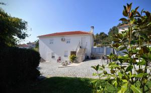 a white house with a staircase leading to a yard at Casa da Avó in Ponte de Lima