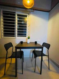 a dining room table with four chairs and a window at Apricot: 1bhk Humble Abode in Botanical Gardens in Hyderabad