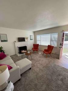 sala de estar con sofá, sillas y chimenea en Entire Home by Newport Beach, Disneyland and SNA! en Costa Mesa