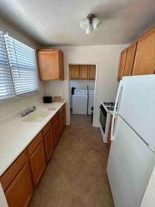 a kitchen with a white refrigerator and a sink at Entire Home by Newport Beach, Disneyland and SNA! in Costa Mesa