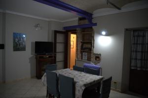 - une salle à manger avec une table, des chaises et une télévision dans l'établissement Tra Langhe e Monviso, à Novello
