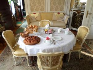 - une table à manger avec une nappe blanche et de la nourriture dans l'établissement Chambre individuelle à lit double dans une maison de Maître de 1904, à Haguenau