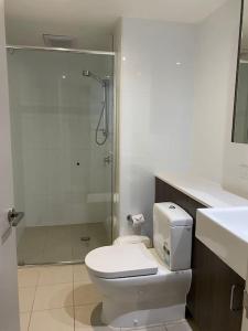 a white bathroom with a toilet and a shower at CBD studio with balcony+pool+gym+sauna in Brisbane