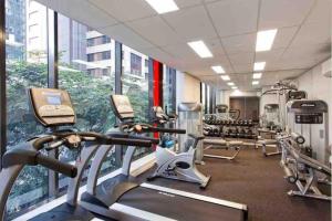 un gimnasio con cintas de correr y elípticas en un edificio en CBD studio with balcony+pool+gym+sauna, en Brisbane