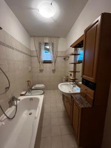 ein Badezimmer mit einer Badewanne, 2 Waschbecken und einer Badewanne in der Unterkunft La Corte Sul Lago casa vacanze in Pisogne