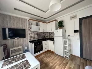 een keuken met een witte koelkast en een tafel bij Deniz One Bedroom Appartment in Mezitli