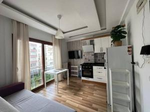 een woonkamer met een koelkast en een keuken bij Deniz One Bedroom Appartment in Mezitli
