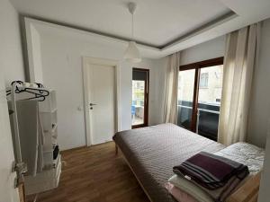 1 dormitorio con cama y ventana en Deniz One Bedroom Appartment, en Mezitli