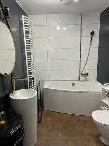 a bathroom with a tub and a toilet and a sink at Mieszkaj U Marty w GRÓDKU in Jaworzno +26 photos
