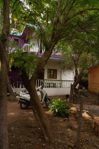 una moto estacionada frente a una casa con árboles en Villa westcost tembewadda colomb, en Canacona