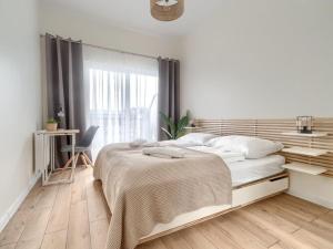 a white bedroom with a large bed and a window at Apartment with beautiful view, Dziwnów in Dziwnów