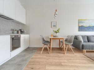 a kitchen and living room with a table and a couch at Apartment with beautiful view, Dziwnów in Dziwnów